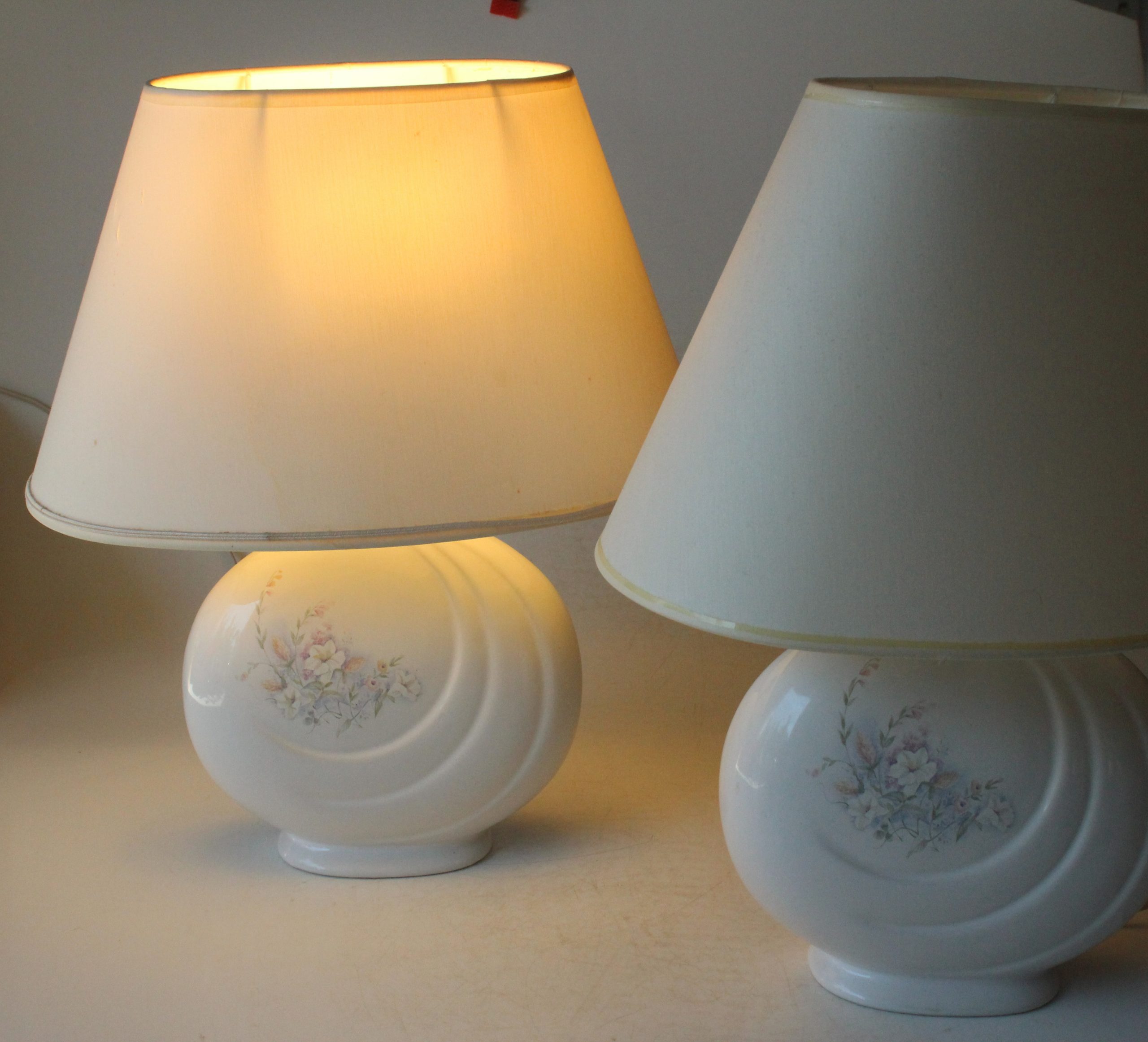 2 Bedside lamps made of white ceramic with floral motifs and with fabric lampshades, vintage from the 1970s